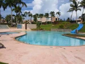a swimming pool in a resort with palm trees at Villa Mango in North Coast in Dorado