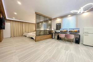 a room with a bed and a desk with chairs at Mungyeong Stay 201 Hotel in Mungyeong