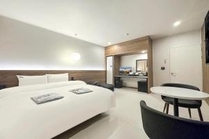 a bedroom with a large bed and a table and chairs at Mungyeong Stay 201 Hotel in Mungyeong