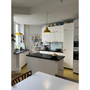哥本哈根的住宿－ApartmentInCopenhagen Apartment 43，厨房配有白色橱柜和黑色台面