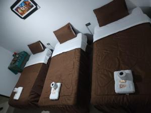 Hotel Huaraz في هواراس: سريرين يجلسون بجانب بعض في غرفة النوم