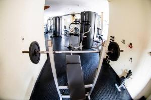 a gym with treadmills and weights at Rosenhaus - HomeClub apto grande com Smartv cozinha piscina in Joinville
