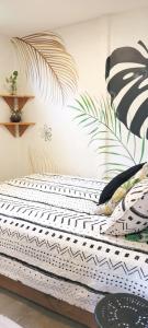 a bed in a room with plants on the wall at Mecca in Puerto Viejo