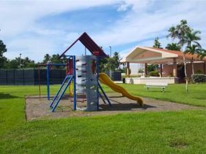 a playground with a slide in a park at Villa Mango in North Coast in Dorado