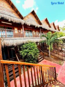 a building with a wooden fence and a building with trees at Lura Bacalar in Bacalar