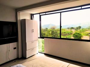 an empty room with a large window with a view at Apartaestudio en combia cerca aeropuerto PEI in Pereira