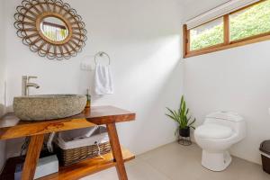 a bathroom with a sink and a toilet at Villa Fruta del Cielo in Uvita +14 photos