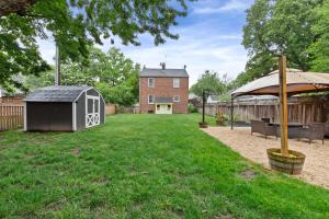 a backyard with a dog house and an umbrella at Stately 5BR Historic Retreat CozySuites in Alexandria