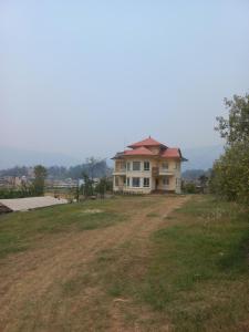 une maison assise au sommet d'une pelouse dans l'établissement Indrayanifarms, à Sundarijal
