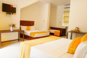 um quarto de hotel com duas camas e uma televisão de ecrã plano em Ananthara Resort em Anuradhapura