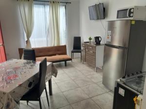 a kitchen and living room with a stainless steel refrigerator at Cabañas Herradura Oriente in Coquimbo