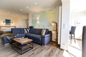 uma sala de estar com um sofá azul e um mapa na parede em Strandhochhaus SB13 em Cuxhaven