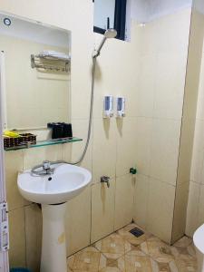 W łazience znajduje się umywalka i prysznic. w obiekcie Khách sạn Phú Hưng w mieście Thái Nguyên