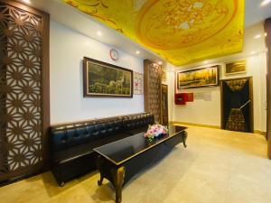 una sala de espera con un sofá de cuero negro y una mesa en Khách sạn Phú Hưng, en Thái Nguyên