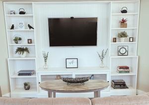 a living room with a tv and a coffee table at Cozy Villa 3 mins to Mohegan- Fully Stocked with King Bed & Fireplace- Jacuzzi, Saltwater Pools, Sauna in Norwich