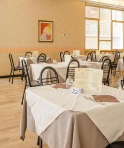 una habitación con mesas y sillas con mantel blanco en Hotel Arena, en Cattolica