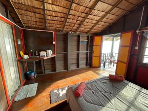 a room with a large bed in a house at Beach Shack Tioman - Beachfront Seaview in Tioman Island
