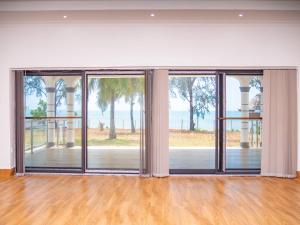 uma sala de estar vazia com portas de vidro deslizantes em Mwambani Beach Villas em Tanga