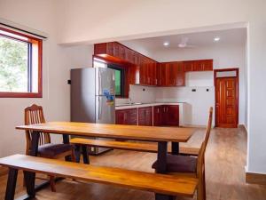 uma cozinha com uma mesa de madeira e um frigorífico em Mwambani Beach Villas em Tanga