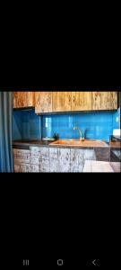 uma cozinha com armários de madeira e um lavatório em ALEXANDER Golden View Serres em Serres