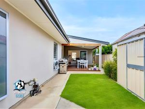 维克多港Light Filled Modern & Stylish 3BR Holiday Home的有绿草如茵的后院的房屋