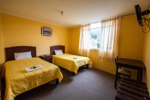 um quarto de hotel com duas camas e uma janela em La Posada de Lucero em Chivay