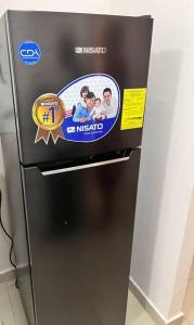 a refrigerator with a picture of a family on it at Acogedor departamento, centrico aeropuerto de Tocumen in Salsipuedes