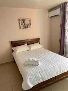 - un lit avec un cadre en bois et des draps blancs dans l'établissement Acogedor departamento, centrico aeropuerto de Tocumen, à Salsipuedes