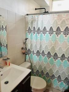 a bathroom with a toilet and a shower curtain at Acogedor departamento, centrico aeropuerto de Tocumen in Salsipuedes
