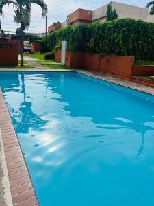 a large blue swimming pool in front of a building at Acogedor departamento, centrico aeropuerto de Tocumen in Salsipuedes