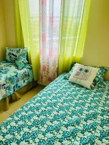 um quarto com uma cama com uma almofada e uma cadeira em Acogedor departamento, centrico aeropuerto de Tocumen em Salsipuedes