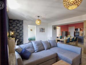 Il comprend un salon avec un canapé bleu et une cuisine. dans l'établissement Appartement Saint-Galmier, 3 pièces, 4 personnes - FR-1-496-276, à Saint-Galmier