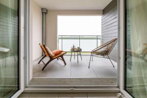 Cette chambre dispose d'un balcon avec une table et des chaises. dans l'établissement Le Havre de Sérénité - Orly - Gare - Place privée, à Athis-Mons