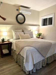 a bedroom with a large white bed with a mirror at Casa Sol in Trujillo