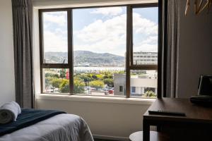 a bedroom with a view of a city from a window at Haka House Wellington in Wellington