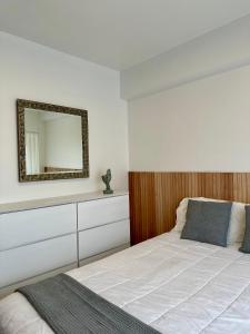 una camera da letto con un letto con uno specchio sul muro di Amplio Departamento en Zona Gastronómica a 3 cuadras de estación Central a Lanús