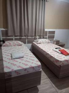 Duas camas sentadas uma ao lado da outra num quarto em Hotel Ferrari em São Paulo