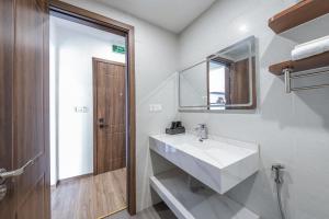 uma casa de banho com um lavatório branco e um espelho. em Hồng Ngọc Hotel em Ðông Thôn