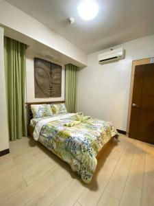 a bedroom with a bed with a green curtain at Fully Furnished Condo in Mactan Newtown with WIFI -Infinity Pool in Lapu Lapu City