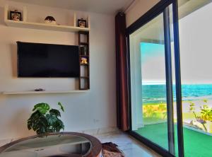 um quarto com uma televisão e uma janela com o oceano em Porto Said شاليه ملكى صف اول بحر بورتو سعيد em Port Said