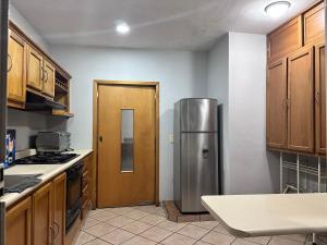a kitchen with a stainless steel refrigerator and wooden cabinets at Casa Valentina in Sayula +10 photos