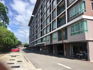 a building on a street with a red car parked next to it at Baan Kun Koey Condo Huahin B103,Pool View,Heart of Huahin,Near Blue Ports,300m from Beach in Hua Hin