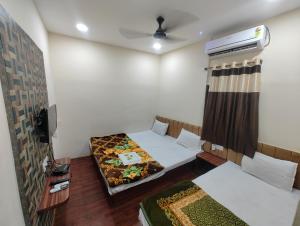 Kleines Zimmer mit 2 Betten und einem TV in der Unterkunft Hotel Standard in Ujjain