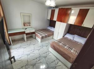 塞德港的住宿－Porto Said شاليه ملكى صف اول بحر بورتو سعيد，客房设有两张床、一张桌子和一面镜子。
