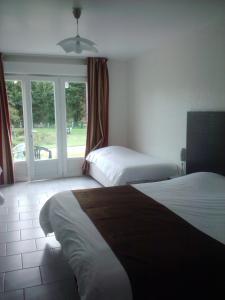 a hotel room with two beds and a window at L'Orée des Châteaux in Bracieux