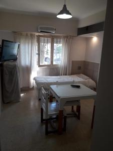 une chambre avec un lit et une table et un lit et une télévision dans l'établissement Departamento Cardiel, à Mar del Plata