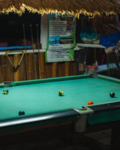 a pool table with two balls on top of it at Beach Shack Tioman - Beachfront Seaview in Tioman Island