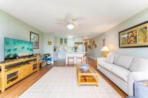 a living room with a couch and a tv at Kuilima Estates East 65 Hale Kai in Kahuku