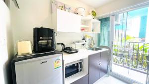 a kitchen with a refrigerator and a microwave at Baan Kun Koey Condo Huahin B103,Pool View,Heart of Huahin,Near Blue Ports,300m from Beach in Hua Hin