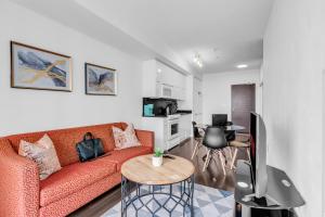 a living room with a red couch and a kitchen at Downtown Condo - Free Parking/Self Check-in in Toronto